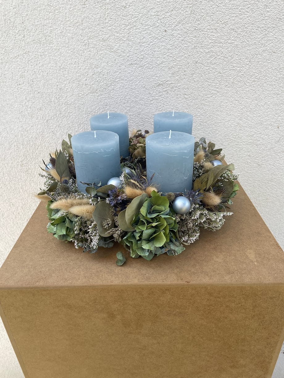 Adventkranz mit Trockenblumen und eisblauen Kerzen